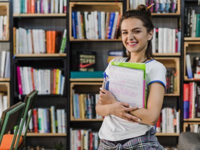 girl-holding-notebooks-pen-smiling